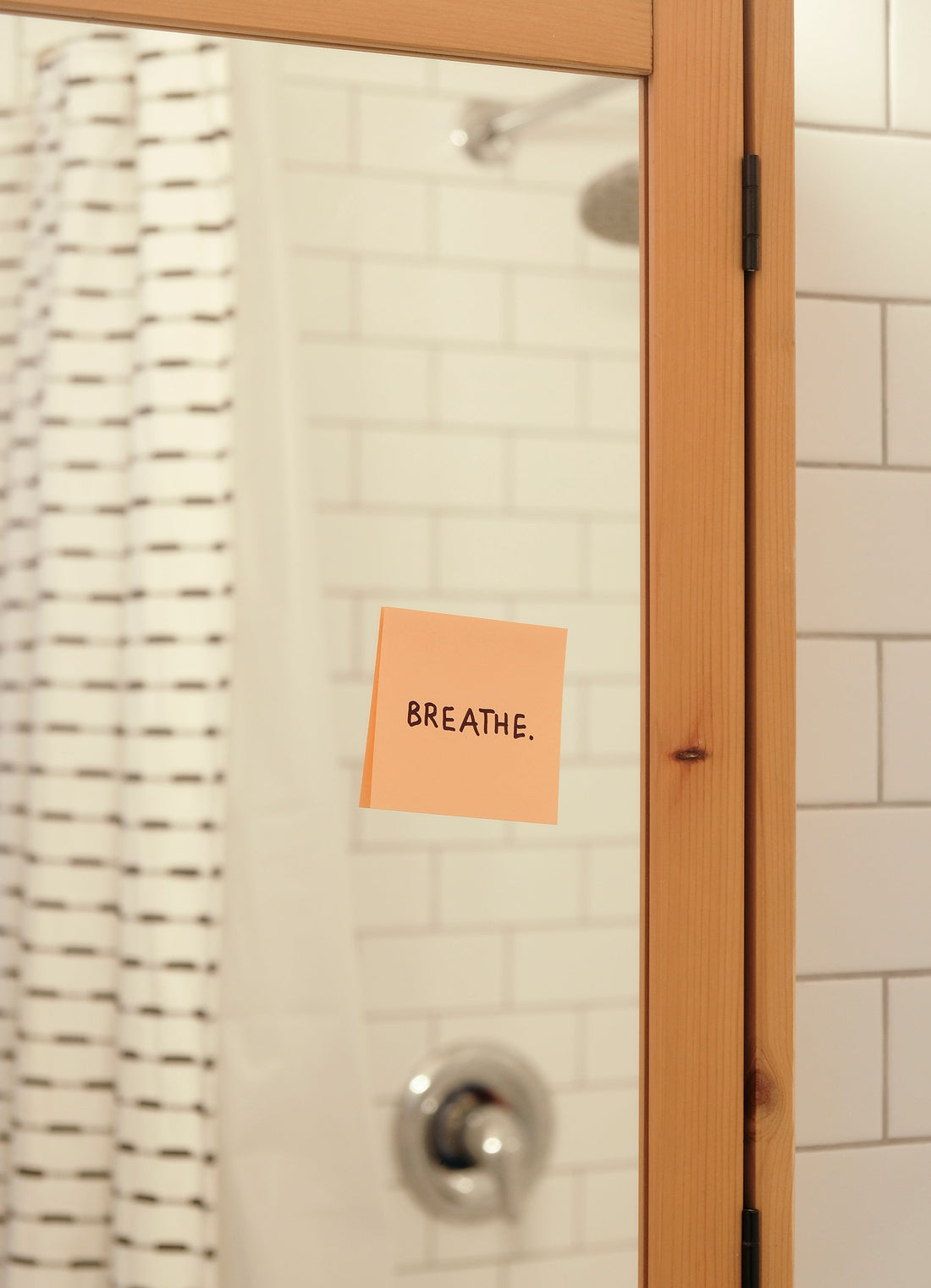 sticky note that says BREATHE on mirror